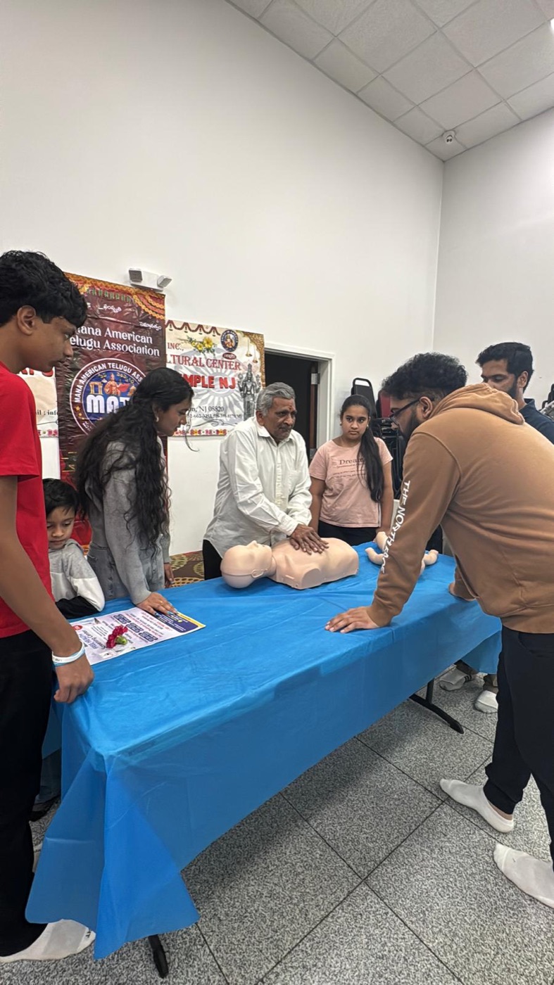 Community members practicing CPR on a mannequin at a MATA health camp